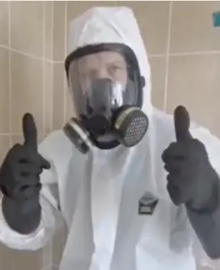 Mold Terminators specialist in full PPE and respirator gear giving thumbs up